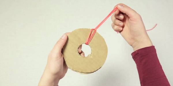 Wickeln Sie die Wolle um die Pompons