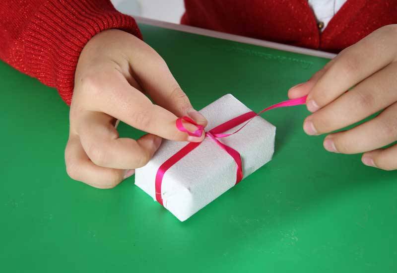 Packen Sie die 24 kleinen Geschenke in weißes Papier.
