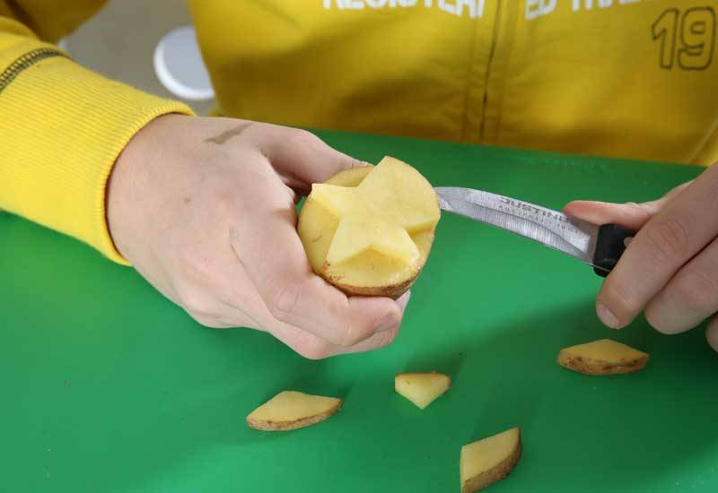 Halbieren Sie eine Kartoffel, schneiden Sie mit Ihrem Kind einen Stern aus.